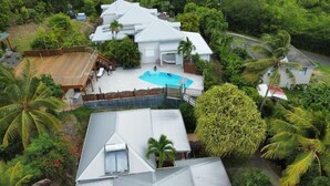 Un quartier résidentiel comprenant plusieurs maisons, une piscine et une végétation luxuriante.