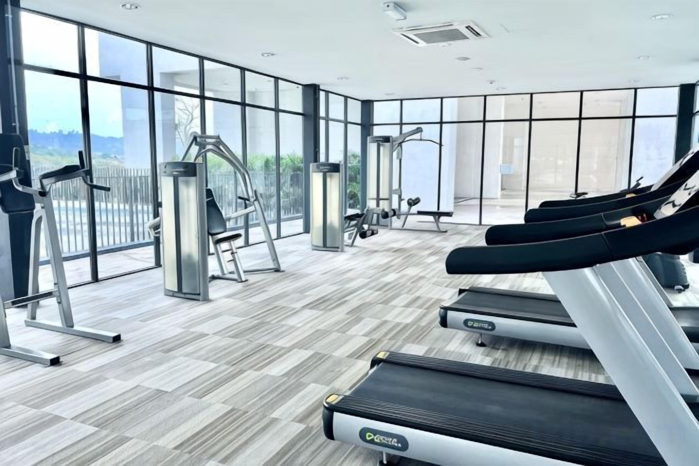 A gym with treadmills, ellipticals, and free weights.