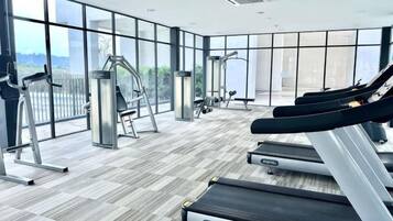 A gym with treadmills, ellipticals, and free weights.
