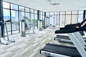 Un gimnasio con cintas de correr, elípticas y pesas sueltas.
