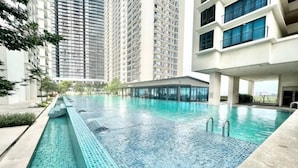 Una piscina con agua azul cristalina, rodeada de edificios altos.
