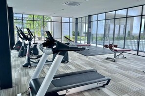 A gym with treadmills, stationary bikes, and a rowing machine.