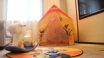 A tent with a cartoon character, a toy horse, and a play mat on the floor.