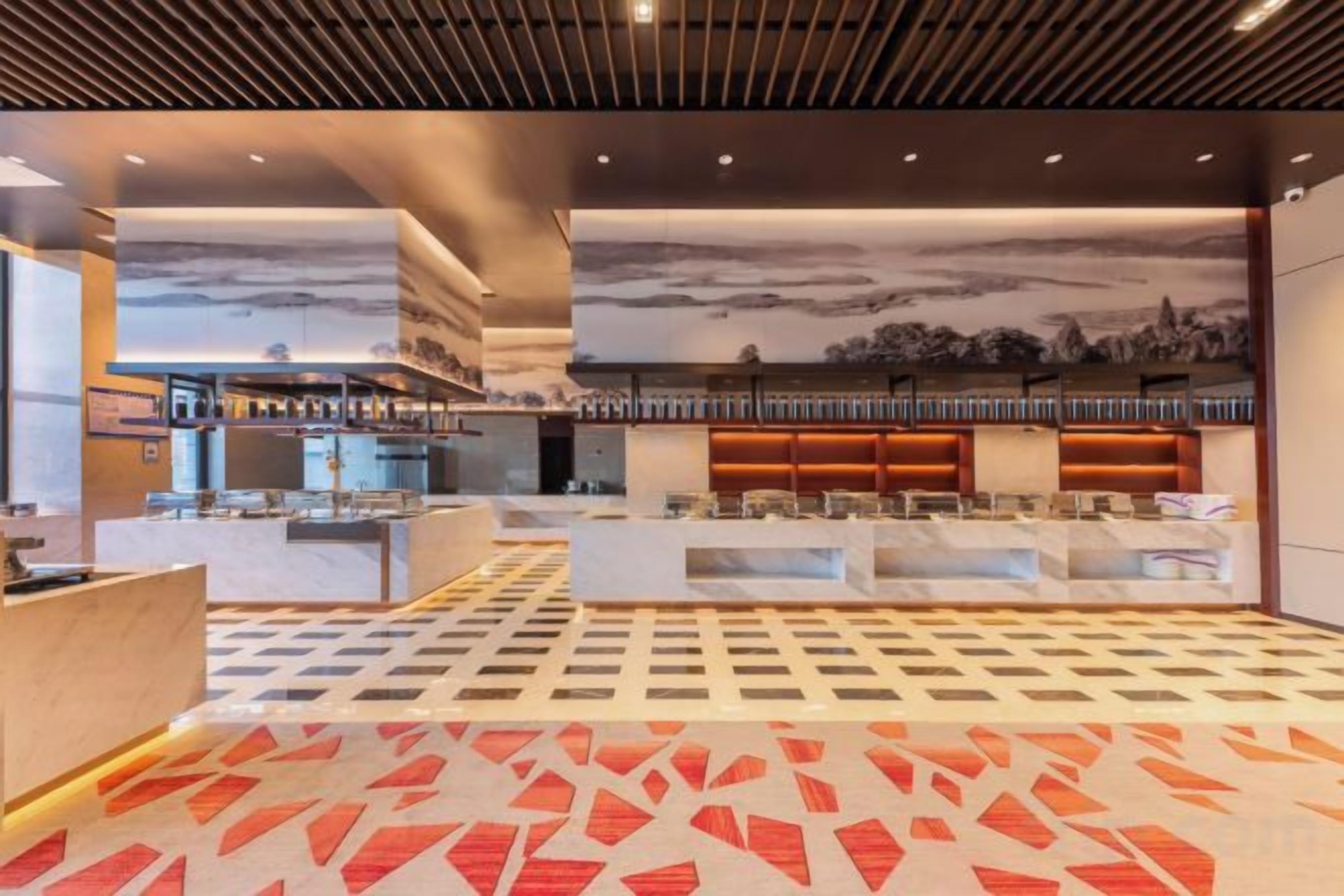 A hotel lobby with a check-in counter, seating area, and a patterned carpet.