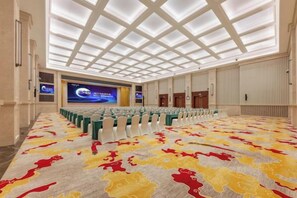A conference room with a large screen, rows of chairs, and a patterned carpet. - Bai an Hotel (Chongqing)