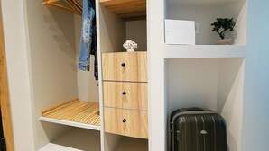 Ein begehbarer Kleiderschrank mit Holoszillen, einer Kleiderstange und einem kleinen Topfpflanzen.