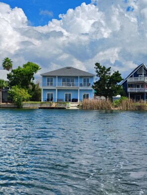 A two-story house with a balcony, situated by a body of water. - Waterfront and Gulfview Retreat Hernando Beach (Hernando Beach)