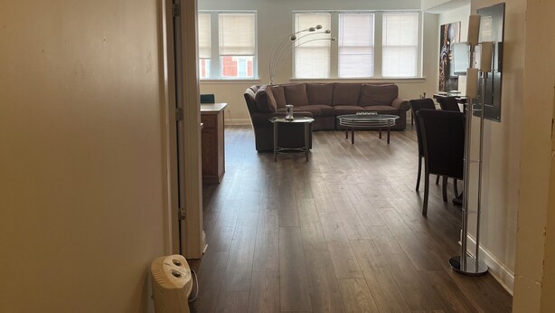 Een woonkamer met een bruine bank, een salontafel en een tv-meubel.