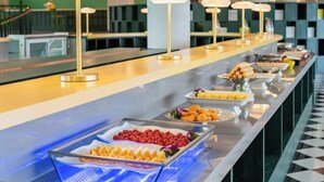 Montaje de bufé con diversos alimentos y un diseño interior moderno.
