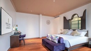 Un dormitorio con cama, escritorio, silla, sofá y espejo.