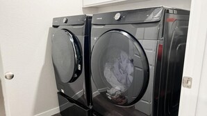 A laundry room with two front-loading washing machines and a dryer. - ROSEVILLE GETAWAY (Roseville)