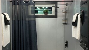 A modern bathroom with a bathtub, toilet, and a shower curtain.