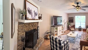 Ein gemütliches Wohnzimmer mit Kamin, einer Couch, einem Couchtisch und einem Essbereich.