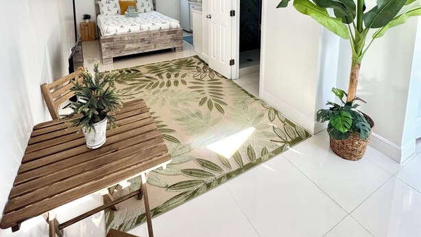 A modern apartment with a dining area, a bedroom, and a living space.