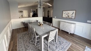 A dining area with a marble table, white chairs, and a patterned rug. - Beautiful Hampton Lakes Home - RECENTLY RENOVATED (Davenport)