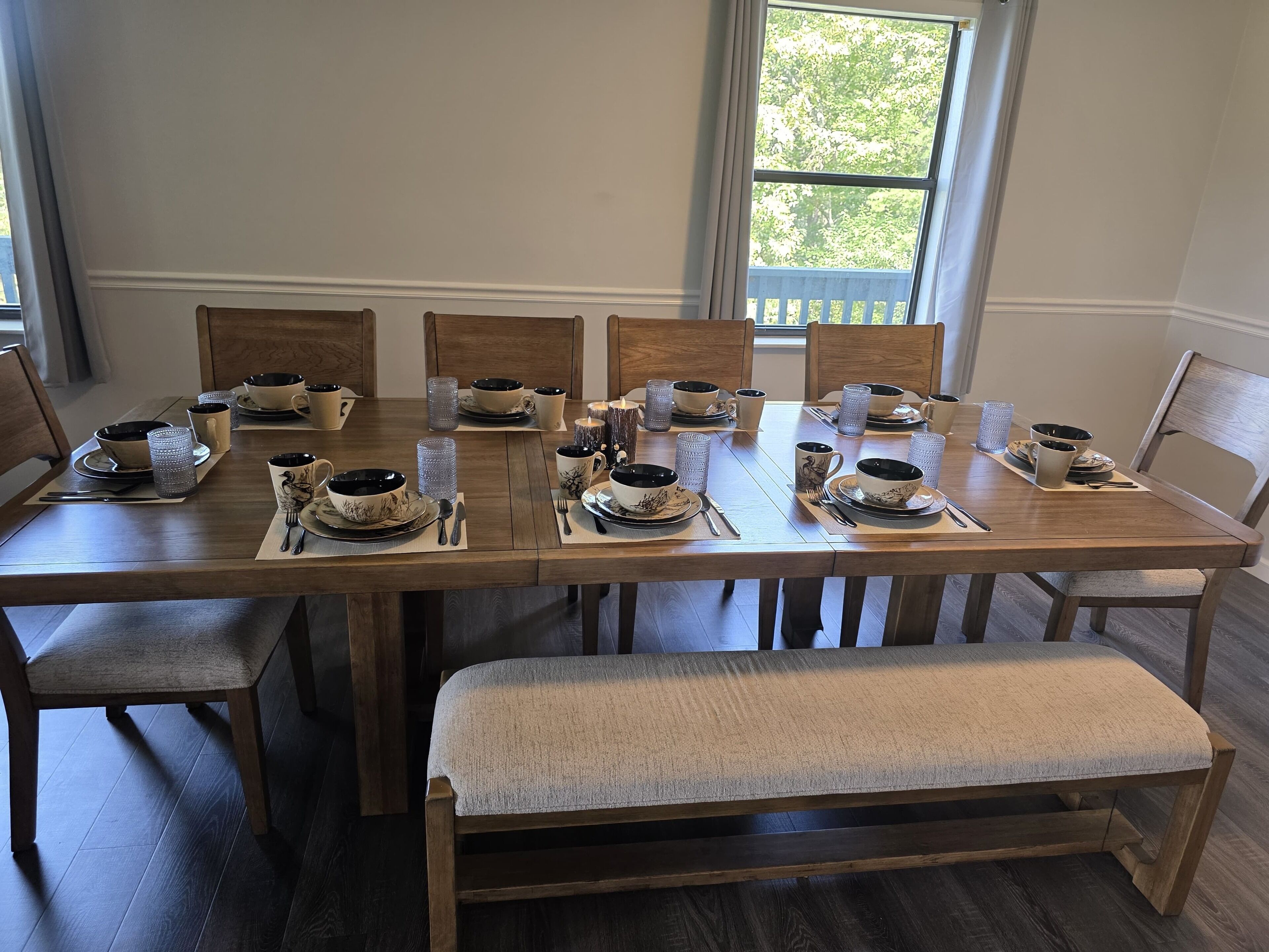A dining table set for six with matching bowls, cups, and cutlery.