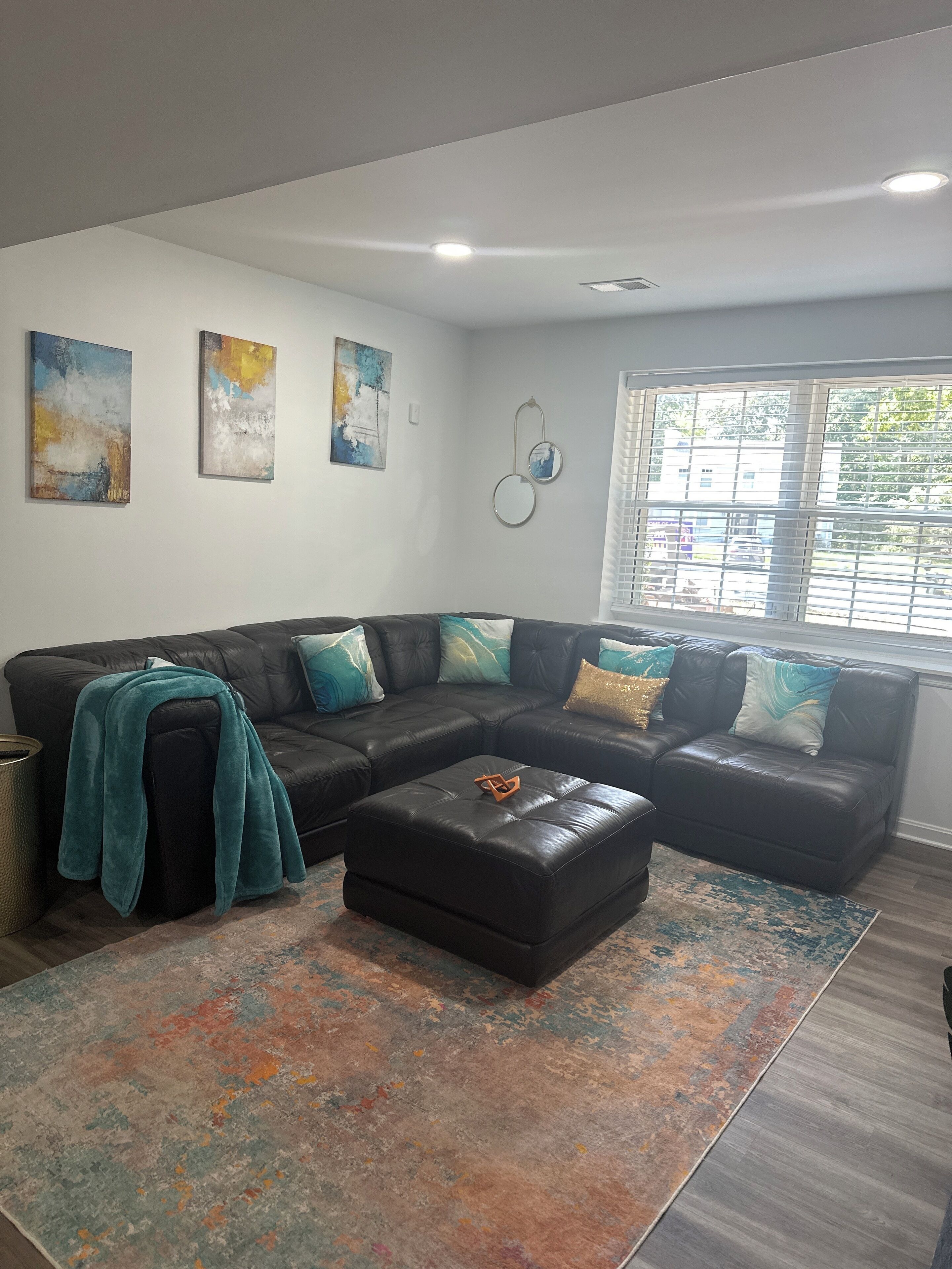 A modern living room with a sectional sofa, a coffee table, and abstract wall art.