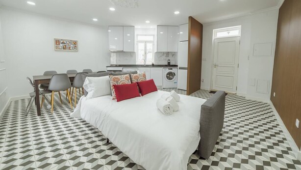 A hotel room with a bed, a dining table with chairs, a kitchen area, and a bathroom. - Lagarteiro House (Porto)