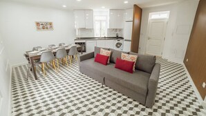 A modern apartment with a dining area, kitchenette, and living room. - Lagarteiro House (Porto)