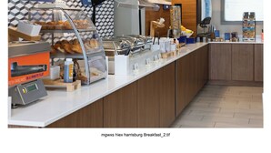 A breakfast buffet area with various food options and a bakery section.