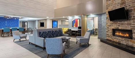 A modern lobby with seating, a fireplace, and artwork on the walls.