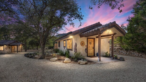 A rustic house with a stone facade, a wooden door, and a gravel driveway. - French Countryside Villa at Dorner Family Vineyard (Tehachapi)