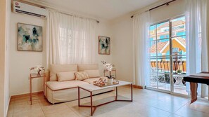 A living room with a sofa, coffee table, and artwork on the walls.