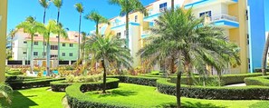 A resort with multiple-story buildings, a swimming pool, and well-maintained gardens.