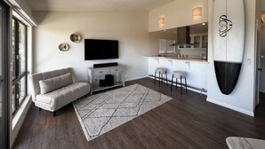 Un salon moderne avec un canapé, un téléviseur et une décoration sur le thème du surf.