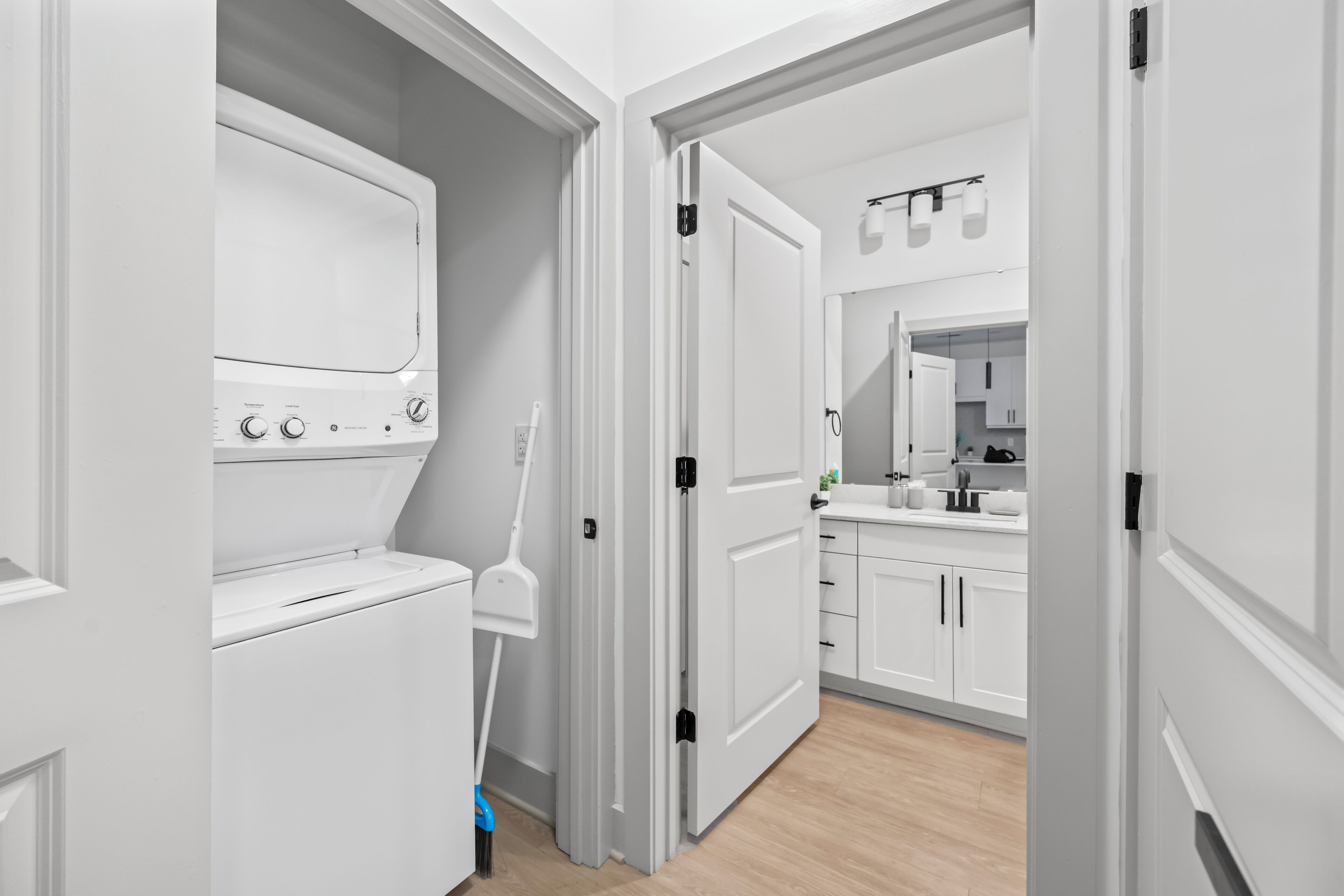 A modern kitchen with white cabinets, a built-in oven, and a countertop with a sink.