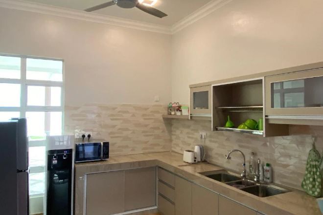 Una cocina moderna con microondas integrado, dispensador de agua y un lavamanos.
