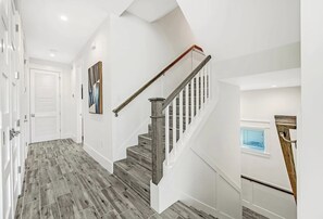 Ein modernes Interieur mit einer Holztreppe, weißen Wänden und einer Tür mit Fenster.
