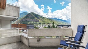Un balcone con vista sulle montagne e su una cittadina.