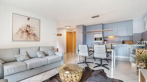 Un soggiorno moderno con un divano grigio, un tavolino in vetro e un quadro grande appeso al muro.