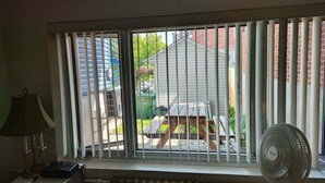 A room with a window, a radiator, a lamp, and a fan.