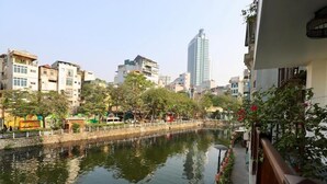 Vista del río con edificios, un puente y un rascacielos alto al fondo.