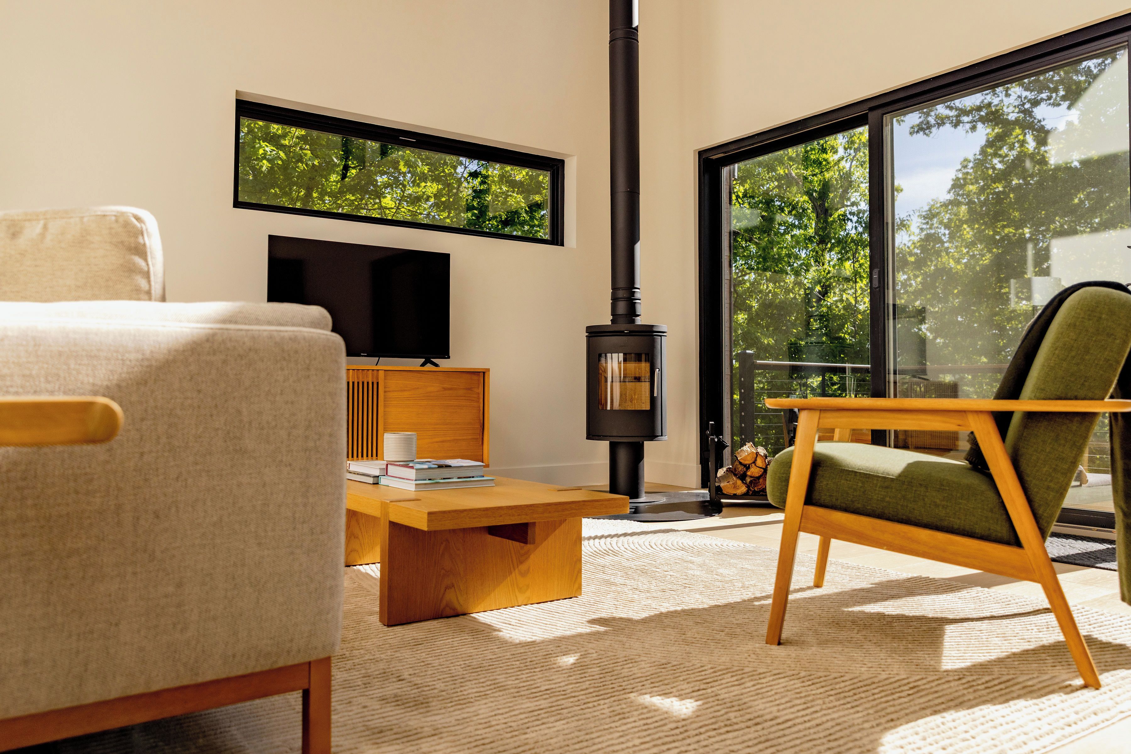 A modern living room with a sofa, a wooden coffee table, a television, and a fireplace.