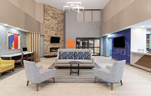 Eine großzügige Lobby mit Kamin, Sitzgelegenheiten und einer Rezeption.
