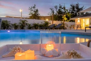 Un décor au bord de la piscine agrémenté de bougies et de pierres décoratives.