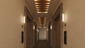 A long, narrow hallway with a tiled floor and walls, flanked by doors and illuminated by wall-mounted lights. - Hyatt Centric Queretaro (Querétaro)