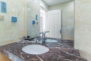 Une salle de bain avec deux lavabos, un miroir et une porte.