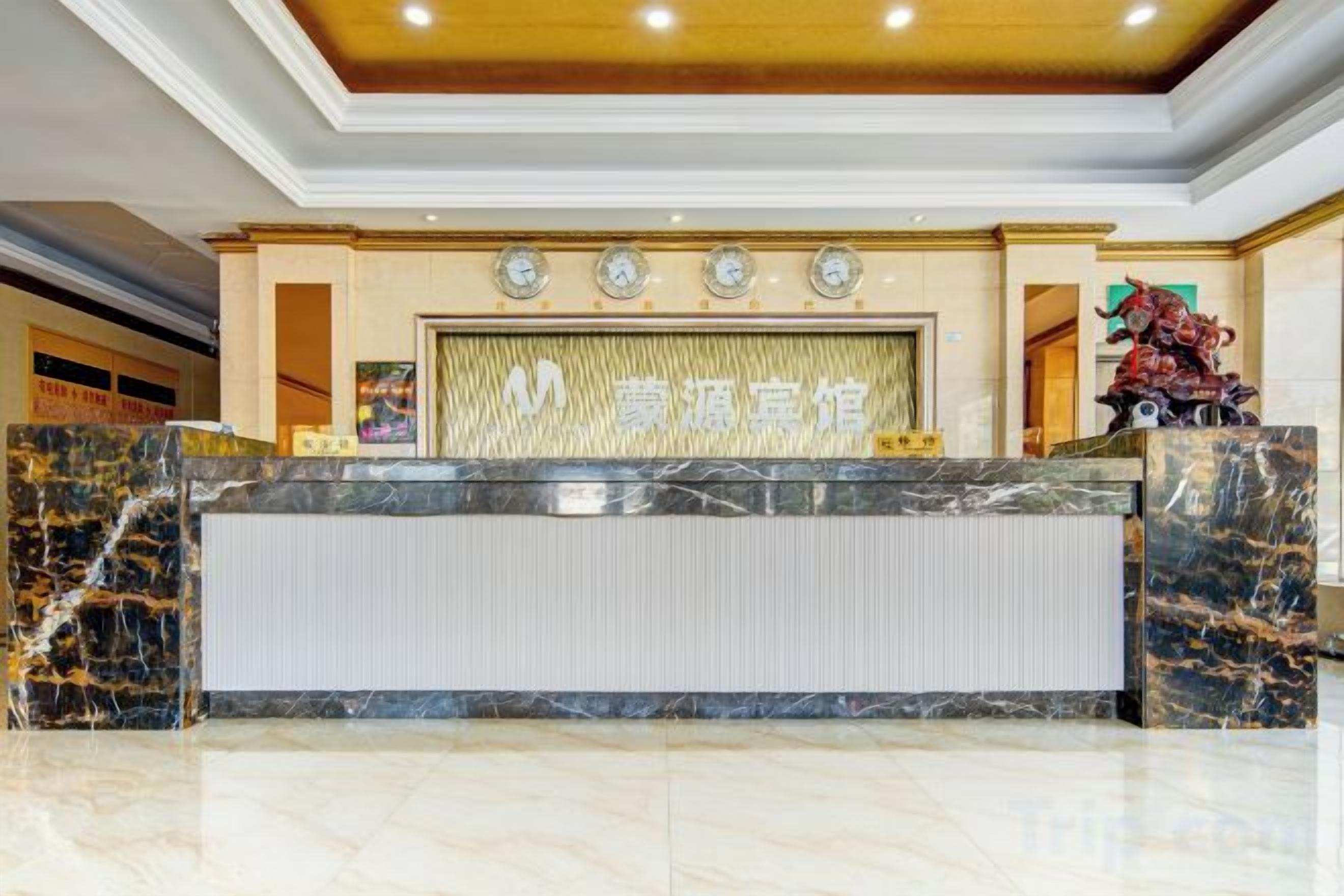 A reception desk with a marble top and a large screen displaying text.