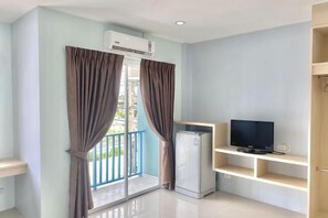 A room with a balcony, a TV, and a refrigerator. - Hop On Phuket (Phuket)