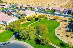 An aerial view of a residential area with houses, roads, and green spaces.
