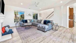 A spacious living room with a sofa set, a coffee table, and a fireplace.