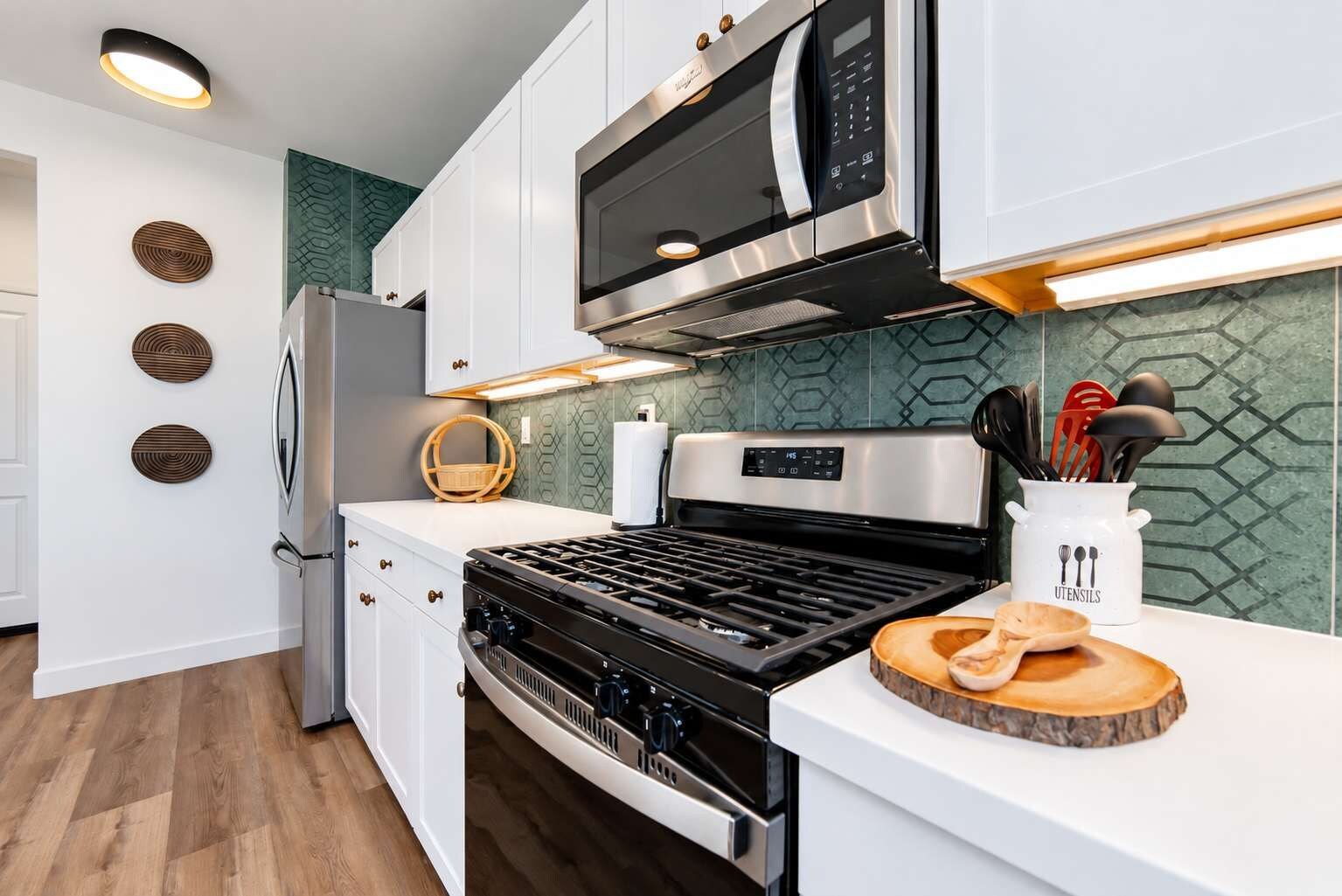 A modern kitchen with a gas stove, built-in microwave, and stainless steel appliances.