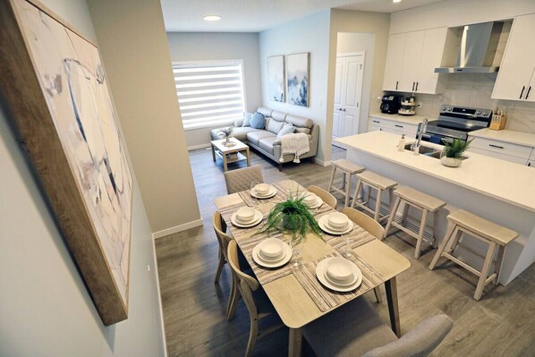 A modern kitchen with white cabinets, a built-in oven, and a coffee maker.