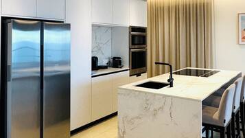 Een koelkast met diepvriezer, een microgolfoven, een oven, een kookplaat