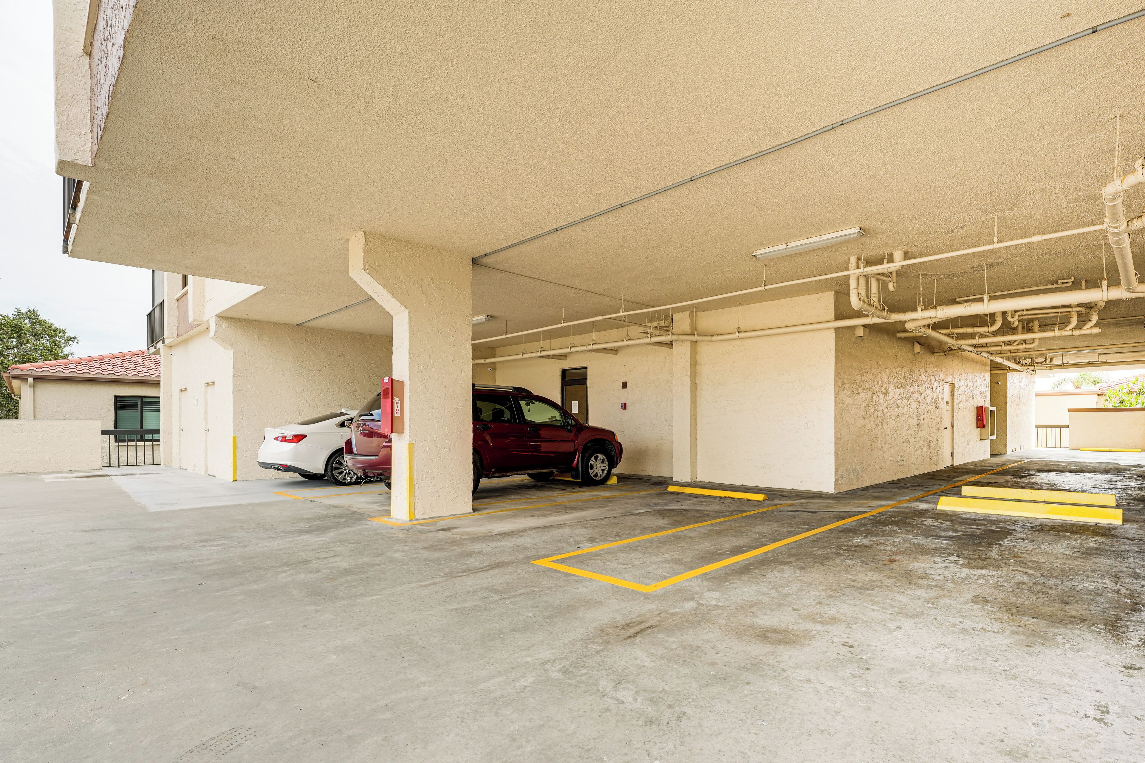 Eine Tiefgarage mit Betonböden und gelben Linien, die Parkplätze abgrenzen.