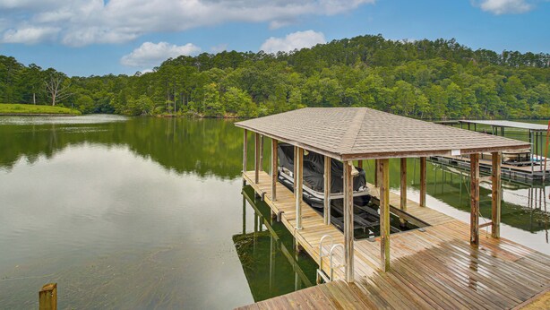 A wooden dock with a covered seating area and a boat. - Tranquil Views: Riverfront Retreat in Hot Springs! (Hot Springs)